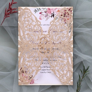 Detail of laser-cut gold glitter butterfly invitation with floral insert on tulle