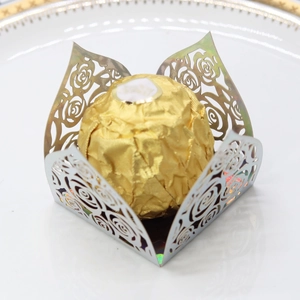 Detailed laser-cut hollow rose pattern on metallic gold cardstock for chocolate decor
