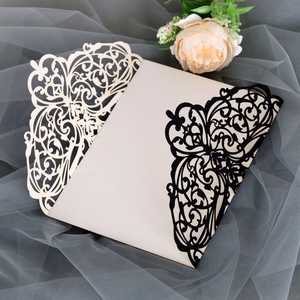 Macro detail of laser-cut black glitter wedding invitation cover with floral patterns
