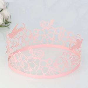 Detail of pink laser-cut cake border with intricate lace bird and flower patterns