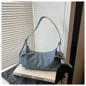 Détail du sac à épaule en denim plissé bleu clair avec boucle latérale et design souple