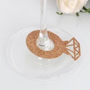 Macro detail of rose gold glitter diamond ring place card on glass stem for weddings