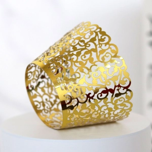 Detail showing golden laser-cut cupcake wrappers with intricate vine pattern decorations