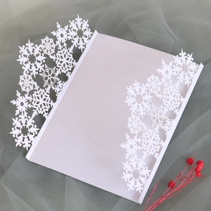 Detailed laser-cut snowflake design on pearlescent white Christmas greeting card