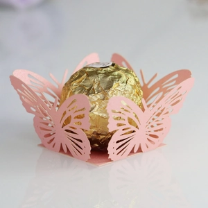 Macro detail of laser-cut pink butterfly candy paper holder with intricate patterns