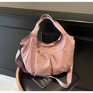 Detail of dusty rose nylon tote bag with multi-pockets and adjustable shoulder strap