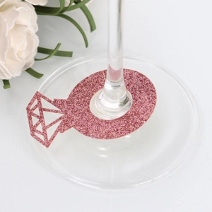 Close-up of pink glitter diamond ring wine glass marker at wedding ceremony