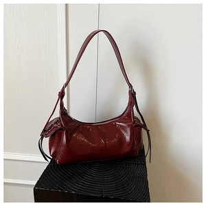 Vue détaillée de la finition en cuir verni bordeaux et du laçage décoratif sur le sac à main