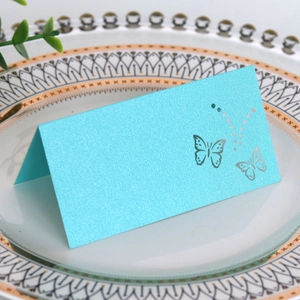 Detail of laser-cut butterfly on bright blue pearlescent paper table place card