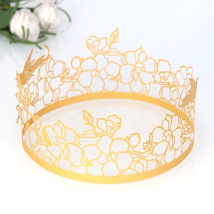 Detailed laser cut gold cake border featuring hollow floral and bird patterns on white background