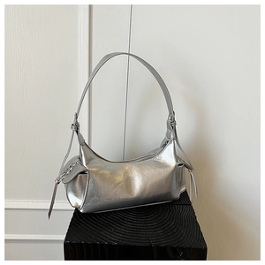 Vue détaillée du sac hobo argenté avec poches latérales et cordons de serrage longs