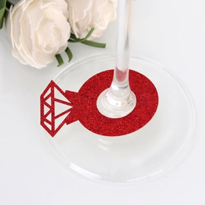 Macro view of red glitter diamond ring place card on a wine glass stem for wedding decor