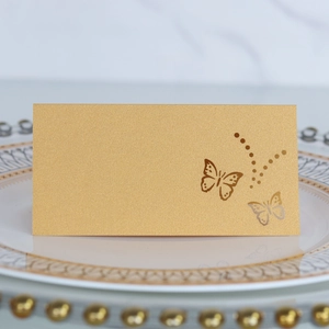 Elegant gold butterfly laser-cut place card displayed on a white plate for weddings