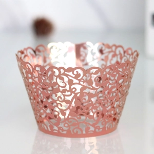 Macro shot of rose gold laser-cut cupcake wrapper with intricate vine hollow pattern
