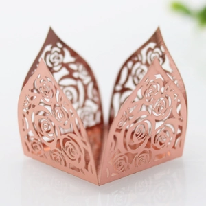 Macro shot of rose gold laser-cut paper cupcake wrappers with intricate floral patterns