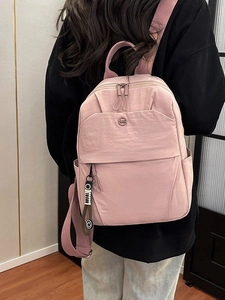 Minimalist light pink nylon backpack for women with metal logo and stylish smiley charm