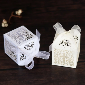 Laser cut favor boxes with cross hollow patterns and ribbon bows for weddings and parties