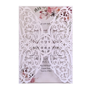 Detail of laser-cut wedding invitation featuring intricate butterfly and floral patterns