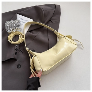 Vue détaillée du sac baguette en cuir crème avec franges et bandoulière réglable