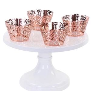 Rose gold laser-cut cupcake wrappers with intricate vine pattern for wedding parties