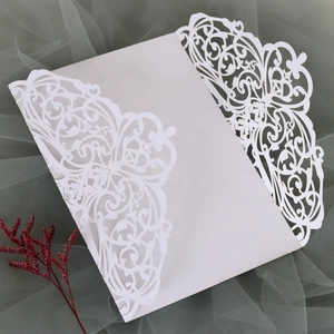 Detailed laser-cut white wedding invitation card with intricate European floral patterns
