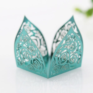 Close-up of laser-cut rose hollow pattern on teal pearlescent cupcake wrappers