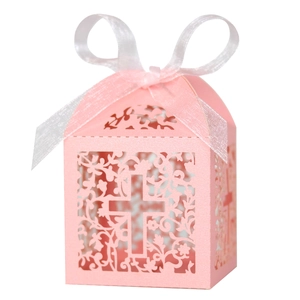Pink laser-cut gift box with white ribbon bow and intricate cross pattern detail