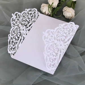 Macro shot of white laser-cut wedding invitation shell with elegant floral hollow patterns