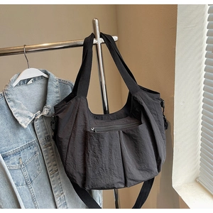 Detail of black nylon tote bag with functional pockets and adjustable shoulder strap