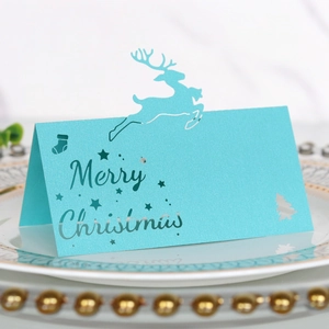 Hellblaue Merry Christmas Tischkarte mit lasergeschnittenem Rentier und Schneeflocken