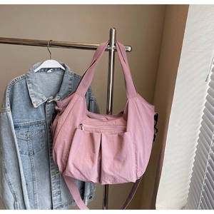 Detail of dusty rose tote bag with multi-pocket design and adjustable strap