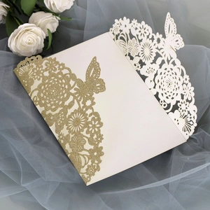 Intricate laser-cut wedding invitation featuring gold glitter butterfly and floral patterns