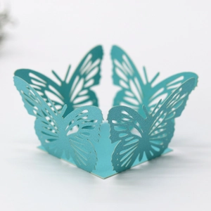 Detail of laser-cut tiffany blue butterfly cupcake wrapper with intricate hollow patterns