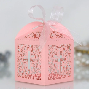 Pink laser-cut wedding favor box featuring floral hollow patterns and a cross symbol