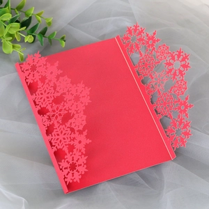 Detail of red laser-cut snowflake Christmas invitation with pearlescent paper texture