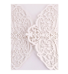 Detailed close-up of ivory laser-cut floral patterns on elegant wedding invitation card