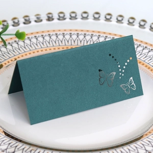 Detail of laser-cut butterfly hollow place card on an elegant white dinner plate