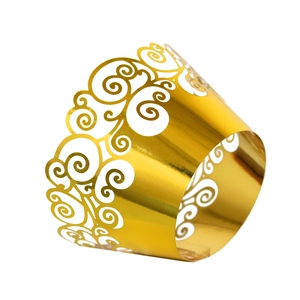 Detail of laser-cut golden cupcake wrapper with intricate scroll patterns and metallic finish