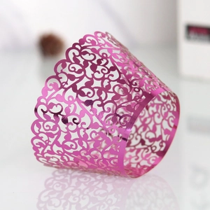 Macro shot of laser-cut pink metallic cupcake wrapper with intricate vine patterns