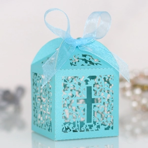 Close-up of light blue laser-cut candy box with cross pattern and silk ribbon bow