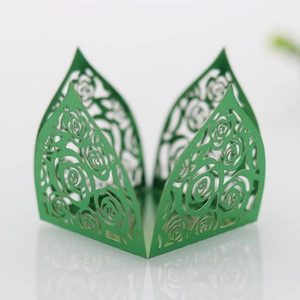 Detail of laser-cut green wedding favor box with intricate rose flower pattern