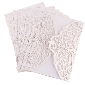 Macro detail of laser-cut floral pattern on elegant white pearlescent wedding invitation