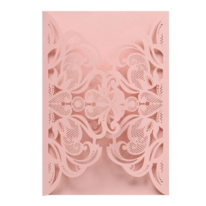Close-up of laser-cut pink wedding invitation card featuring elegant floral lace patterns
