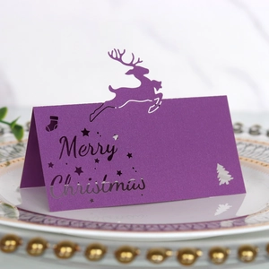 Lasergeschnittene lila Rentier-Platzkarte mit Merry Christmas-Schriftzug auf einem Teller