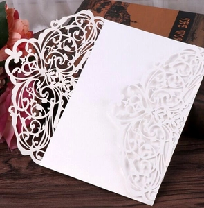Detailed laser-cut vine patterns on white wedding invitation card cover
