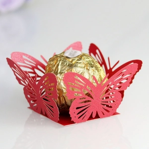 Detail of red laser-cut butterfly chocolate holder with a gold foil truffle