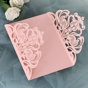 Detailed laser-cut floral pattern on pink wedding invitation with rose decoration