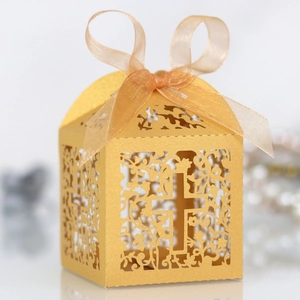 Macro shot of gold laser-cut candy box with cross pattern and elegant ribbon bow
