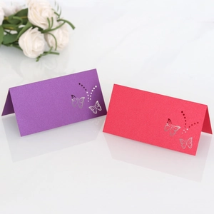 Detail view of laser-cut butterfly place cards with gold foil on pearl paper