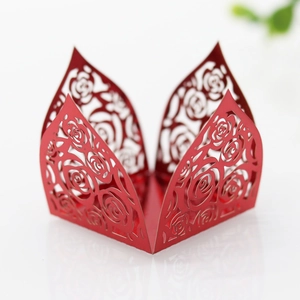 Detail of red laser-cut hollow rose pattern on pearlescent paper for wedding decor
